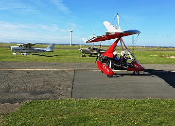Red Microlight taking off for another trip to Anglesey