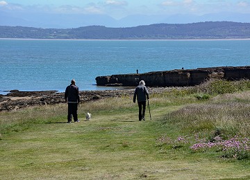 Walking along the headland in summer at Moelfre